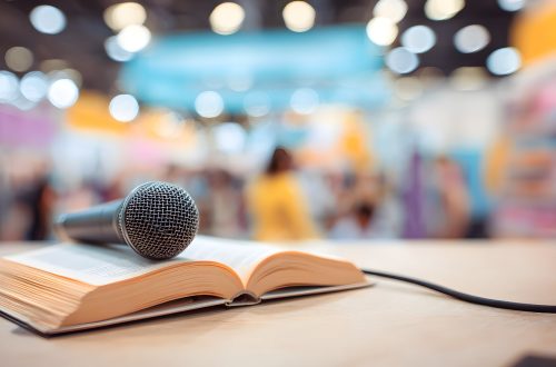 Microphone resting on an open book at a conference venue with bokeh lights